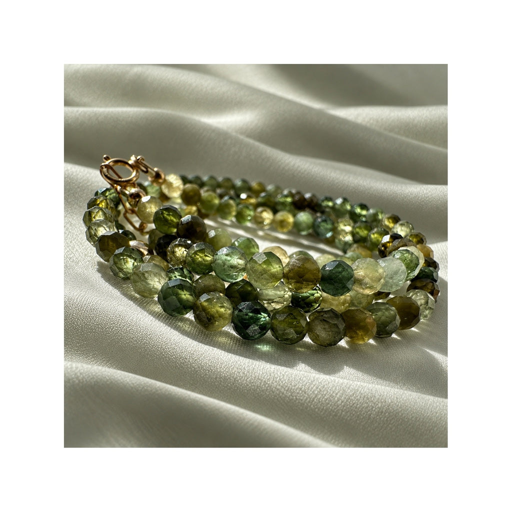 Close-up of natural faceted green tourmaline gemstones in the FOREST GREENS necklace
