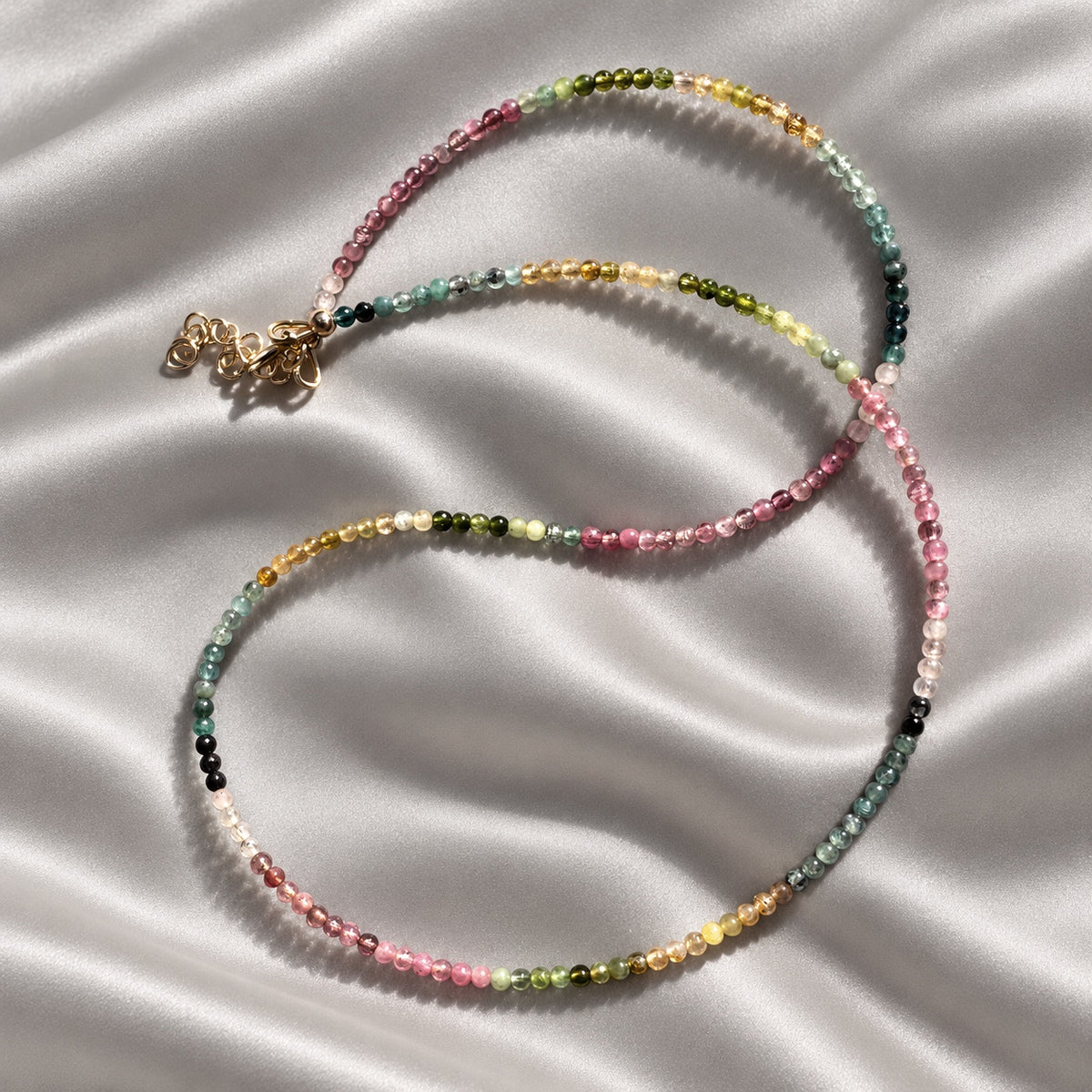 COLOUR POEM tourmaline necklace arranged in two loose loops, with smooth 2 mm pink, blue, green and yellow beads on pearl-grey silk