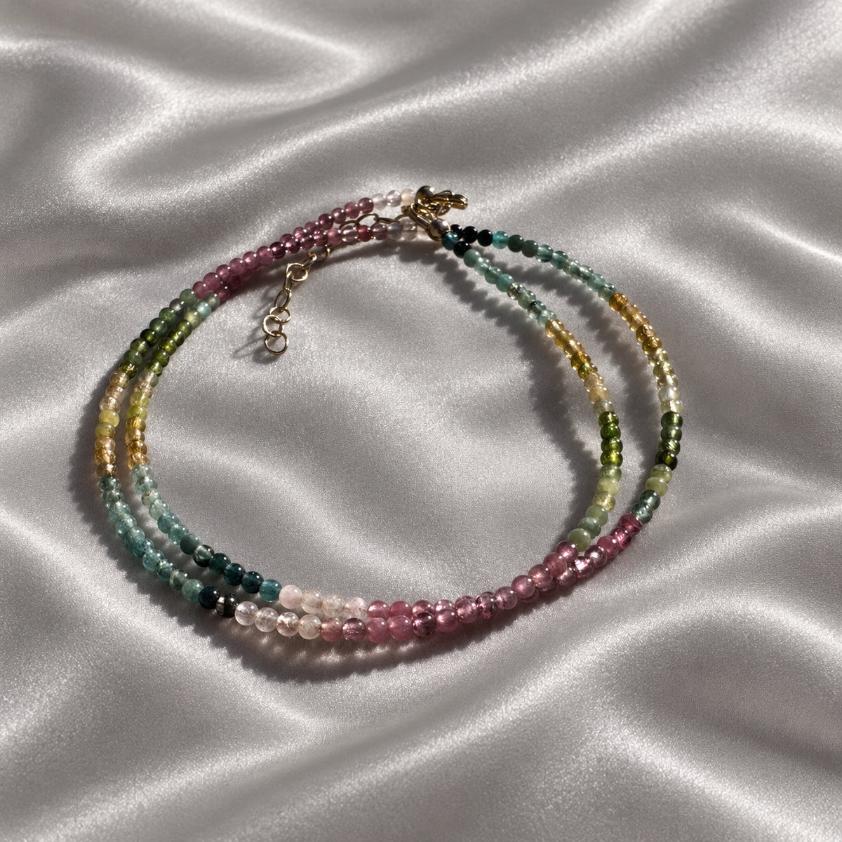 COLOUR POEM natural tourmaline necklace arranged in a double oval, showing smooth multicolour beads and gold-filled clasp and extension chain